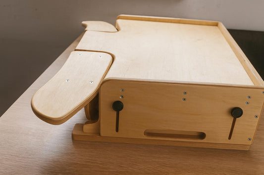 Desktop workbench for watchmaking and jewelry work, featuring adjustable tabletop height, ergonomic armrests and solid plywood build.