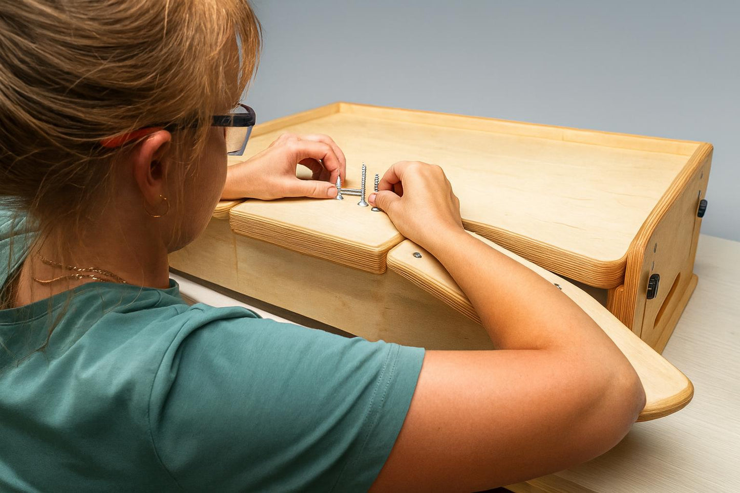Desktop workbench for watchmaking and jewelry work, featuring adjustable tabletop height, ergonomic armrests and solid plywood build.